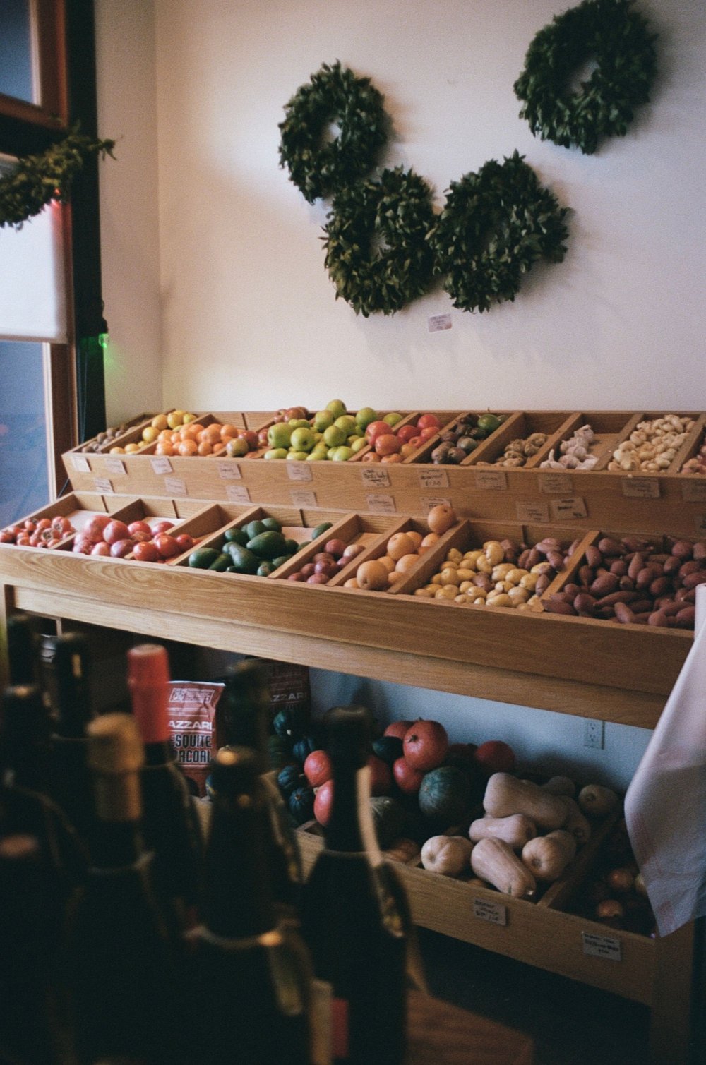 Ladenregal aus Holz mit Obst und Gemüse in Fächern